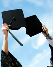 Graduates tossing mortarboards.