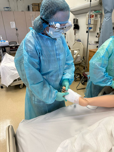 Nursing Exploration Project member wrapping an injured synthetic patient's foot.