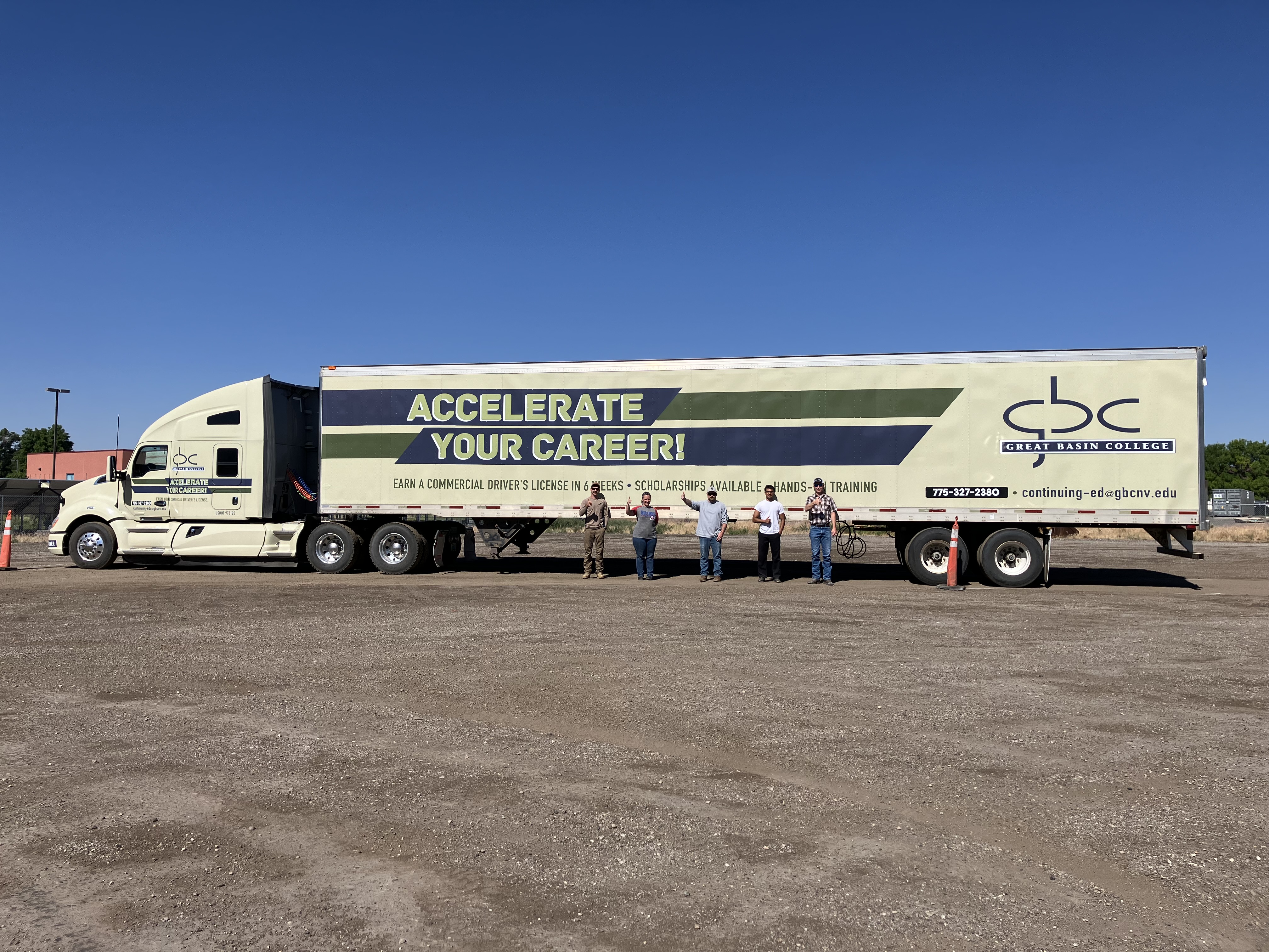 CDL truck drivers in front of class Commercial drivers stand in front of a truck branded "GBC Accelerate Your Careers"