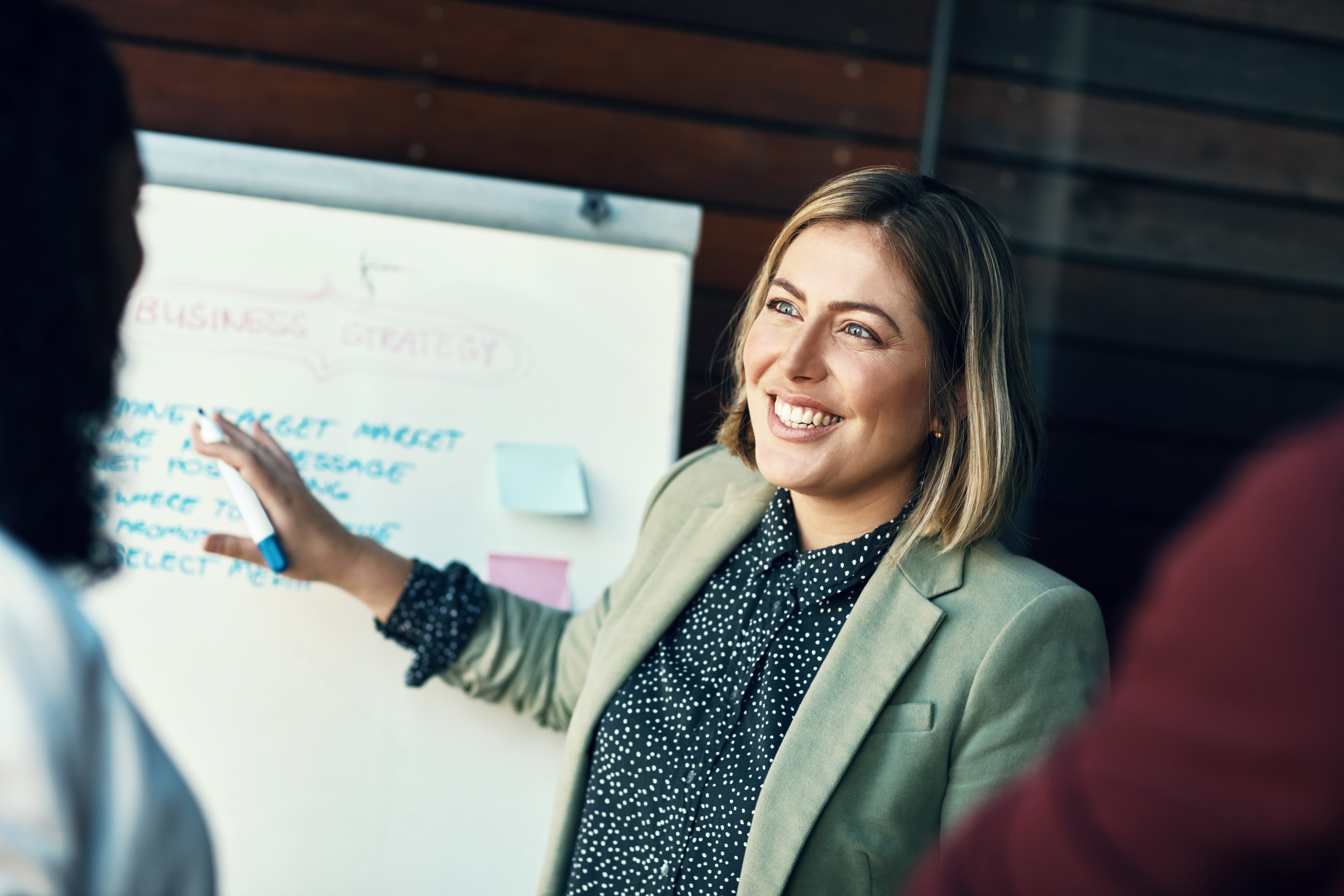 Management and Supervision Woman is dicussing something with colleages pointing to a presentation board