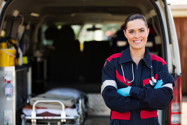 Female EMS Paramedic standing next to an ambulance.