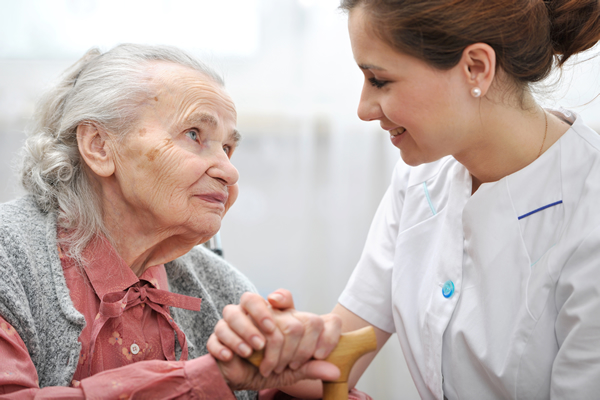 Female Nursing Assistant helping an elderly woman.