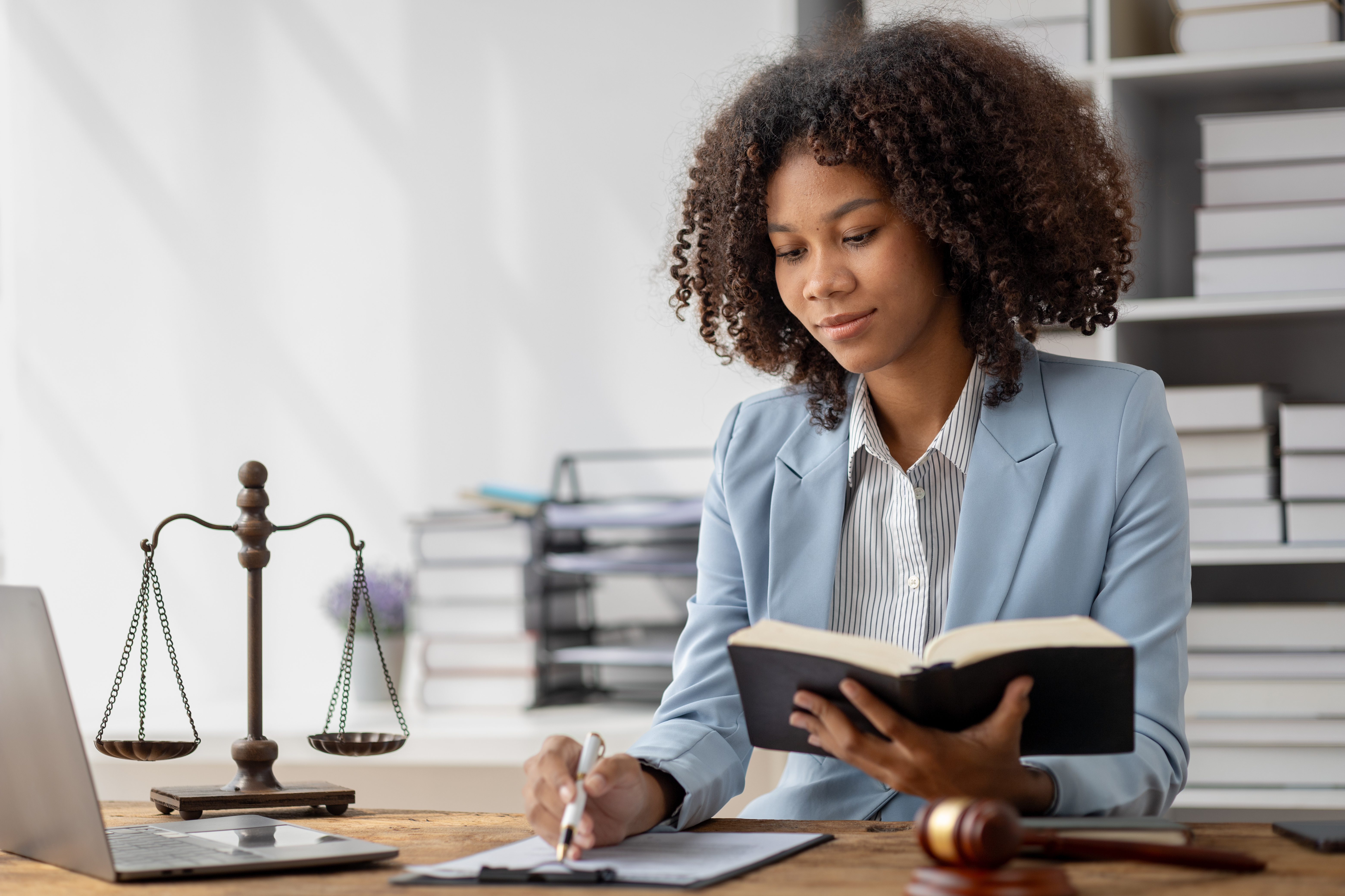 Criminal Justice. Female lawyer sitting at a desk surrounded by law books.